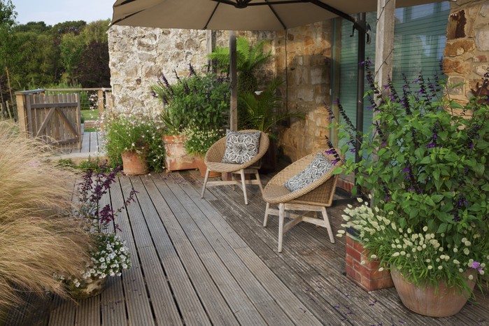 The generous deck is sheltered from the prevailing winds and is a perfect place to sit and enjoy the views. Containers bring the garden up to the house and are replanted seasonally.