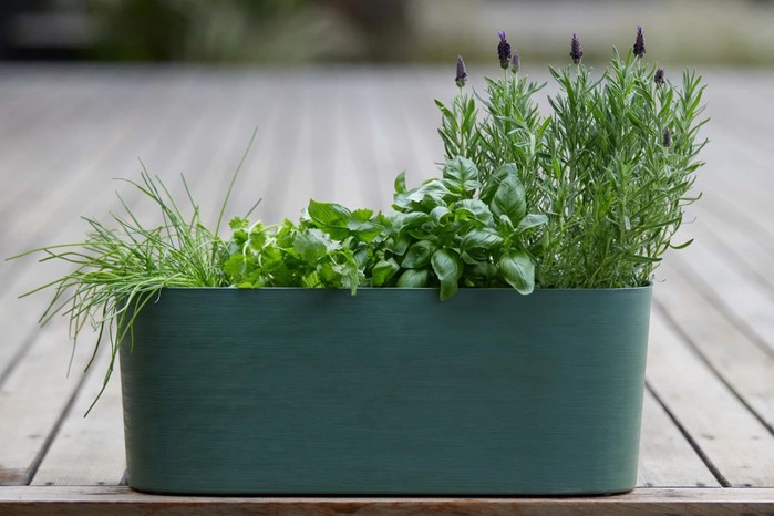 Paros Recycled Plastic Self-Watering Trough Planter on a garden decking